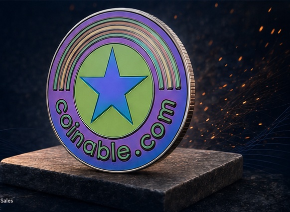 Coinable.com challenge coin on a dark stone pedestal with subtle sparks